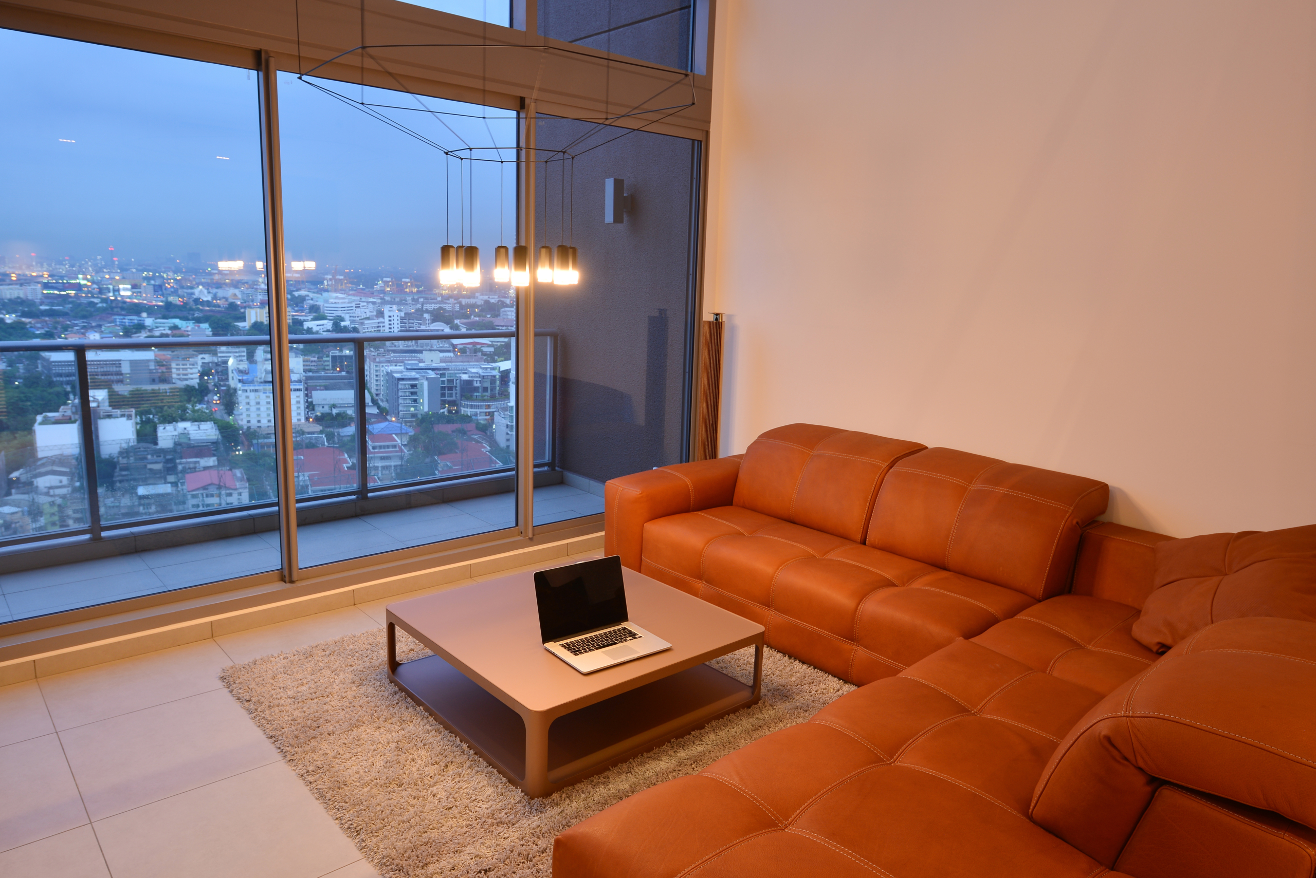 Laptop in luxury modern living room interior and decoration at night, interior design The Grand Residence